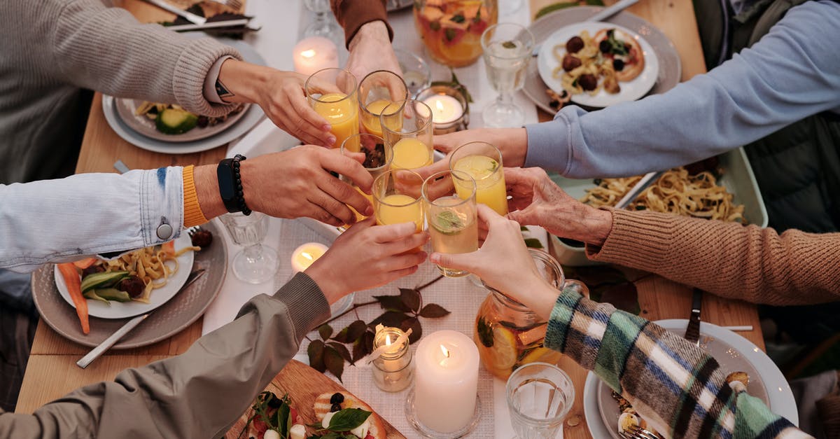 Alcohol when flying to Singapore from EU through Malaysia - From above of crop friends enjoying dinner with candles while cheering with glasses of drinks