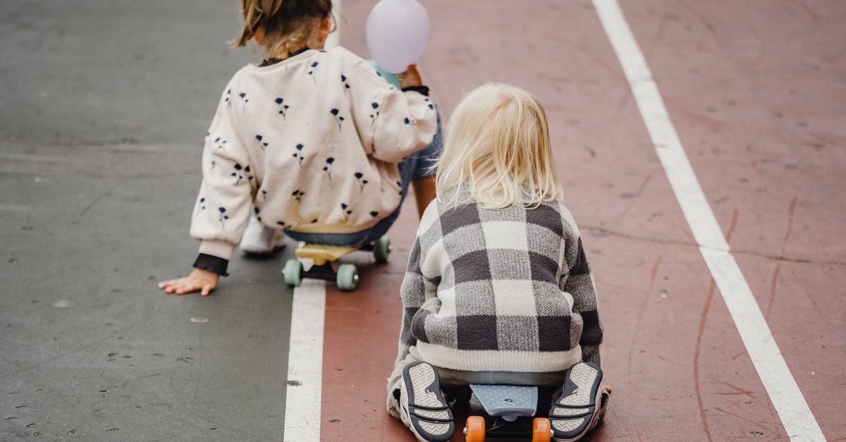 All day vs street parking in Edinburgh and Glasgow - Faceless children sitting on skateboards on asphalt road