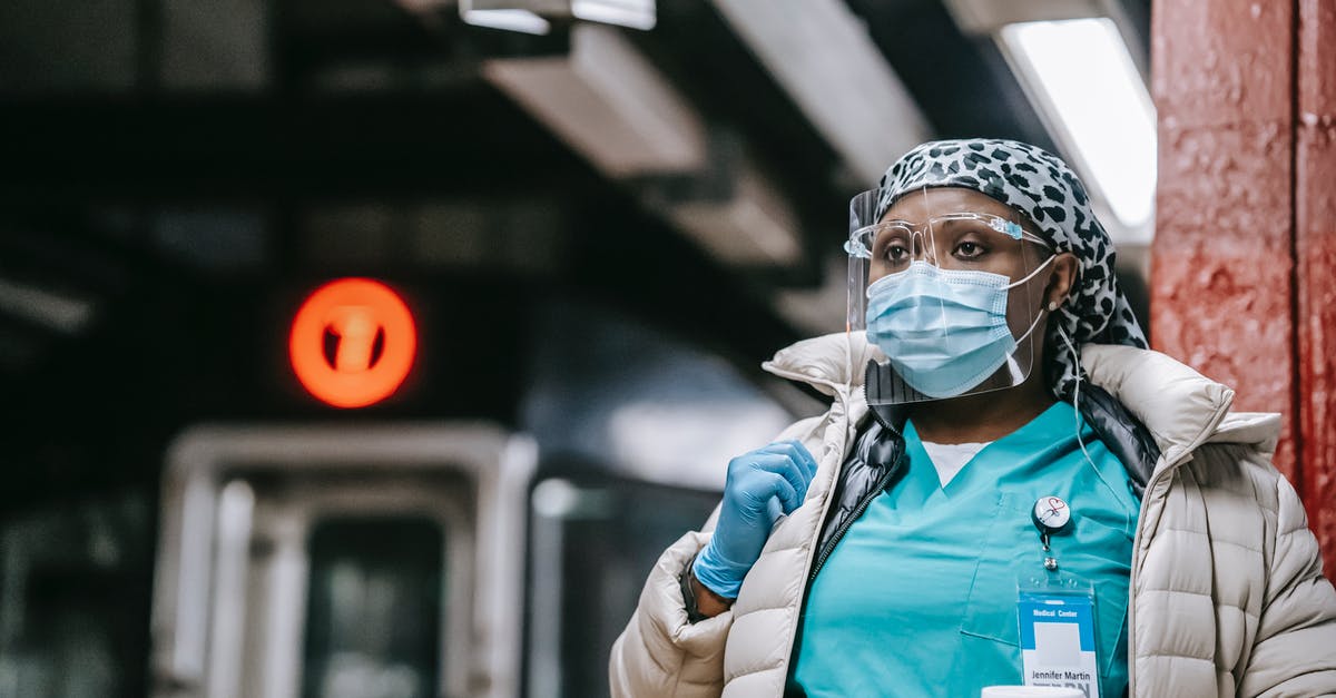 Am I expected to tip wait staff in Europe? - Pensive black nurse in respirator waiting for train on platform