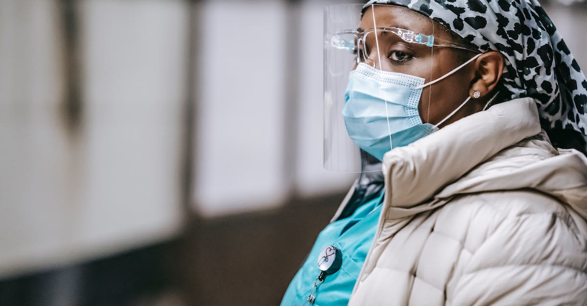 Am I expected to tip wait staff in Europe? - Calm adult African American female doctor in outerwear and protective mask and face shield waiting for train on underground platform and looking away pensively