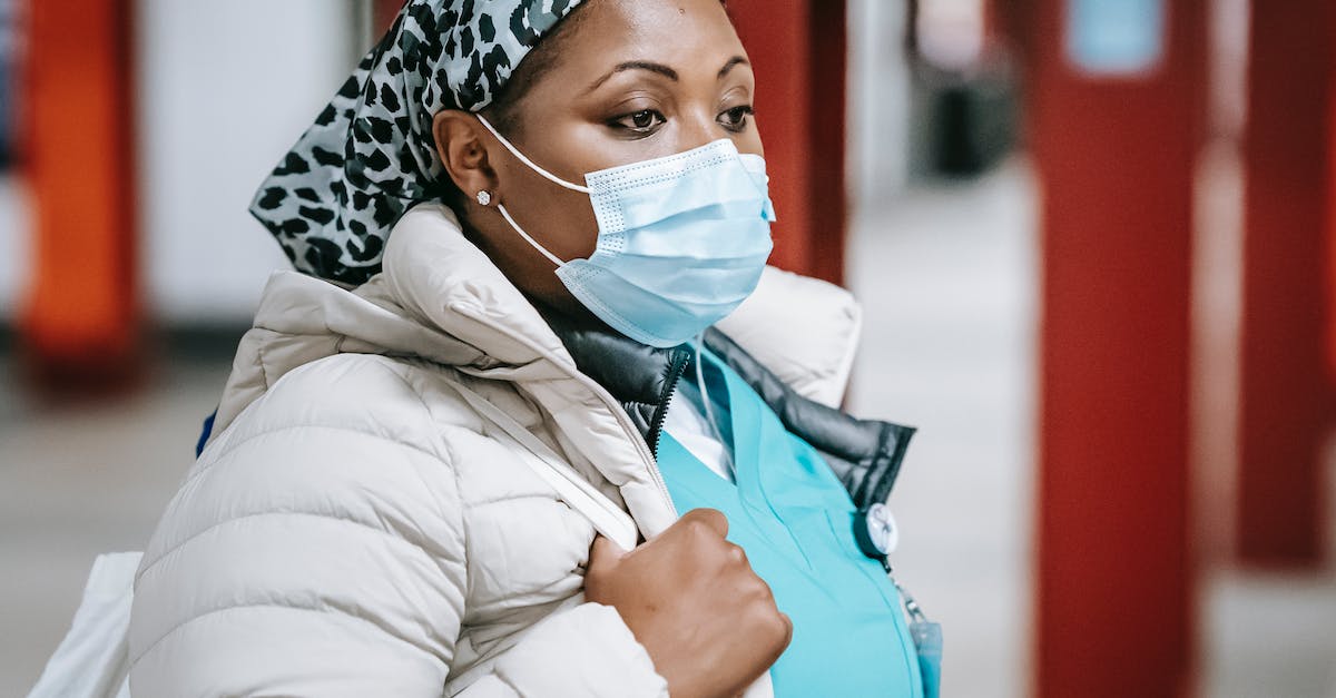 Am I expected to tip wait staff in Europe? - Pensive black nurse in mask standing in public place