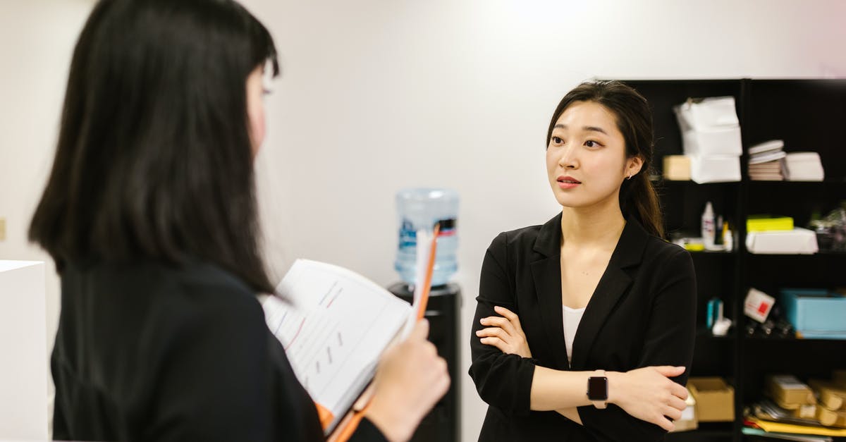 Am I over-staying in the Philippines? Japanese Dual citizen - A Woman Listening to a Coworker at an Office