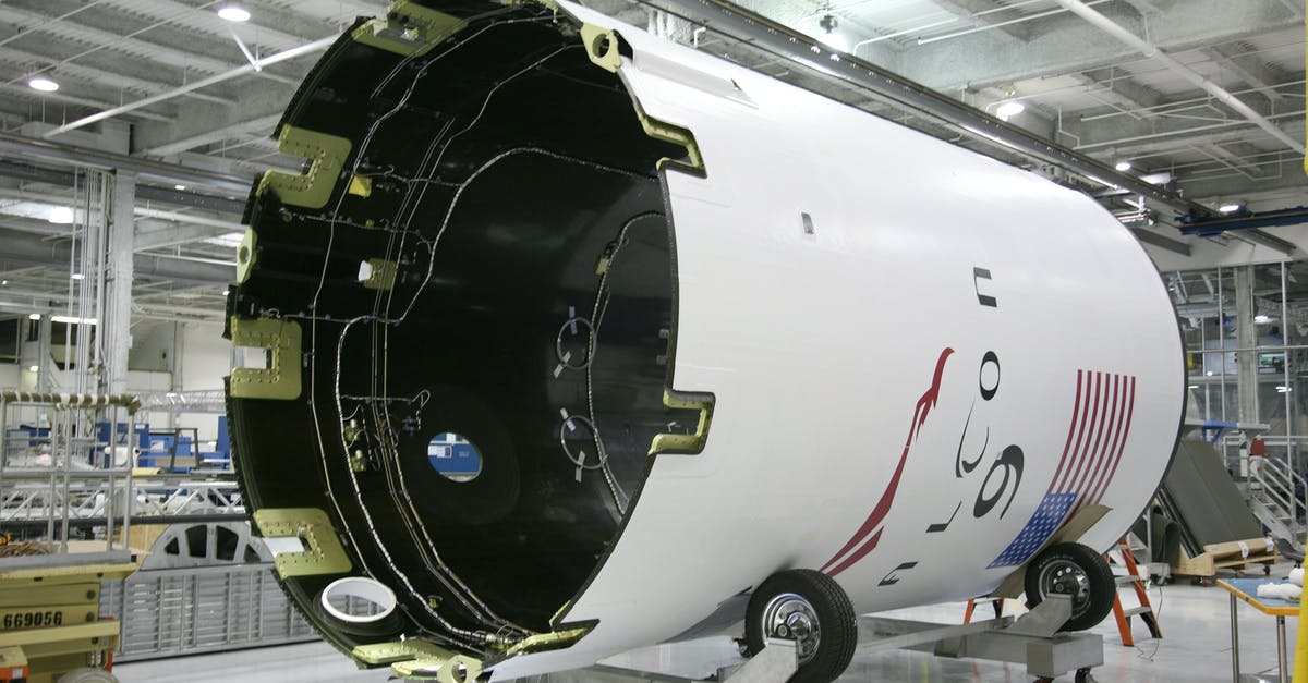 American Airlines: The class of service may not be available - From below of exterior detail of rocket with inscription and American flag placed on rolling platform at modern factory