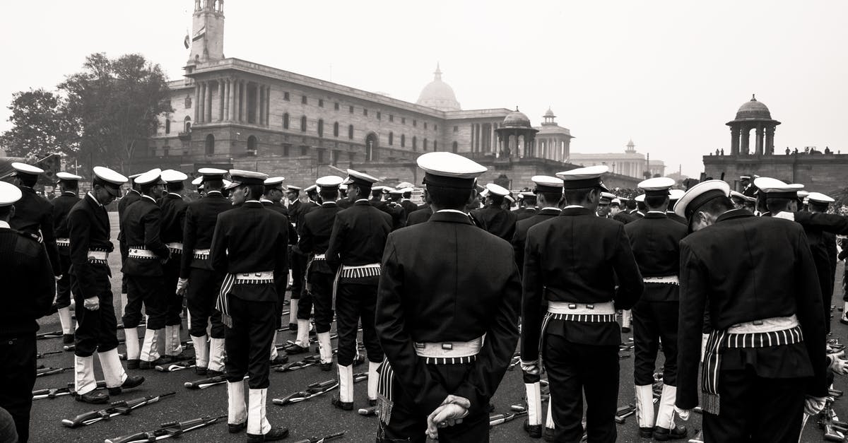 American Allowance in Schengen Area vs Having a Schengen Visa in Schengen area - Black and white multiethnic men in military uniform standing in rows near automatic guns lying on ground during military parade on square near old buildings with turrets on daytime