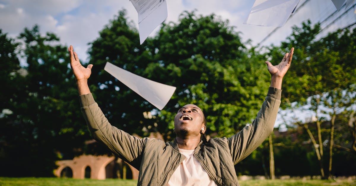American citizen, resident in Israel, getting student visa for France - Cheerful young African American male student in casual clothes throwing college papers up in air while having fun in green park after end of exams