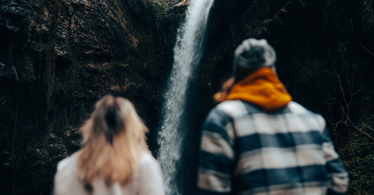 American coming to Scotland from overstay in Spain - Unrecognizable Couple Looking at Waterfall Coming from Rock