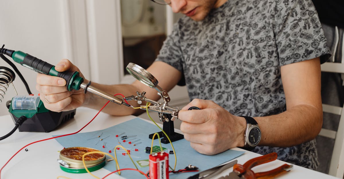 An extra battery in a hand luggage? - A Man Using a Soldering Iron