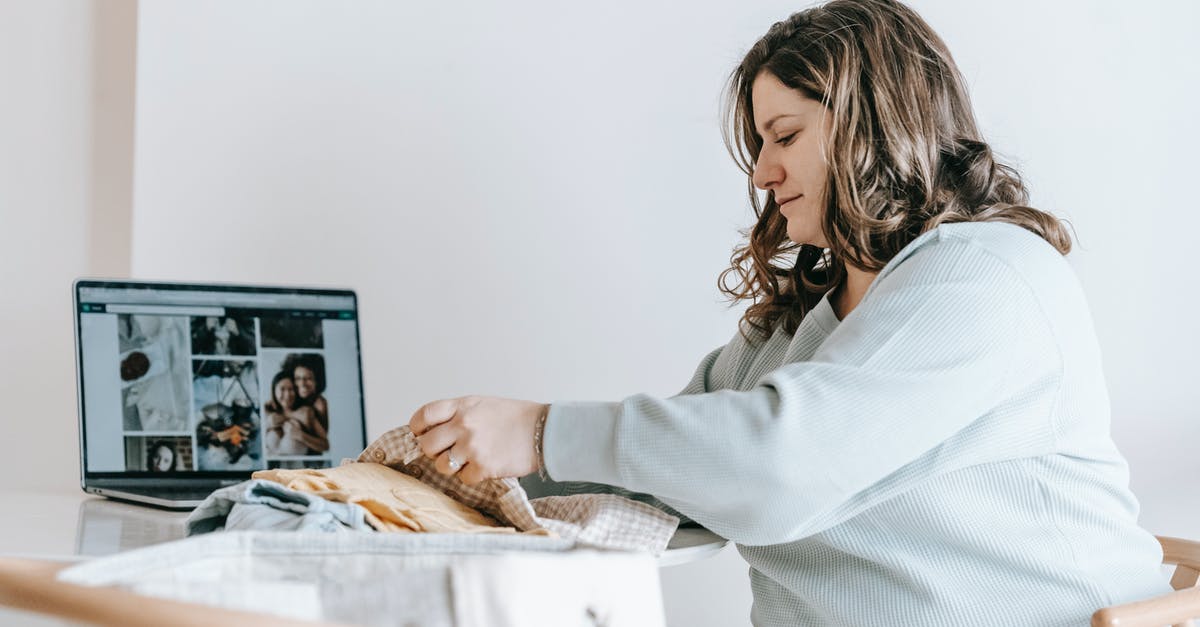 ANA domestic carry-on allowance: can I take a laptop bag as well as a rucksack? - Woman folding baby clothes near laptop