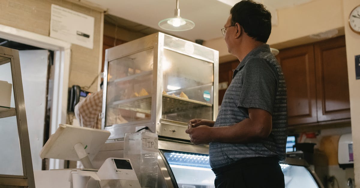 Any cash machine in central London which can dispense £5? - Side view of ethnic male wearing casual clothes standing near showcase and cash register while buying food in grocery store