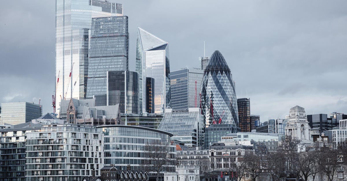 Any cash machine in central London which can dispense £5? - Modern multistory business centers with geometric architecture located on street against cloudy sky in downtown of London city in financial district