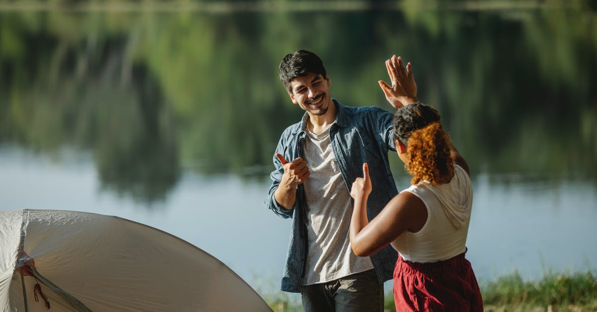 Any other sites like darjeleen or flightfox? - Glad male hiker with unrecognizable ethnic female beloved showing thumbs up and giving high five while looking at each other in campsite