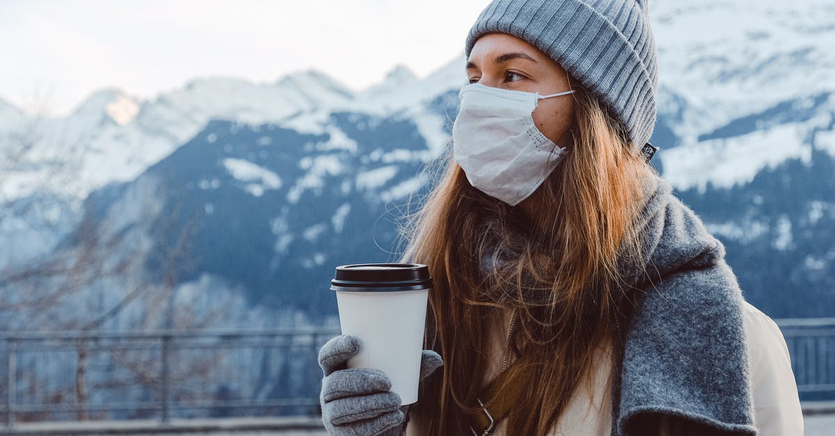 Any Restricted Personal Items While Travelling To Singapore? - Woman in Gray Knit Cap Holding White Disposable Cup