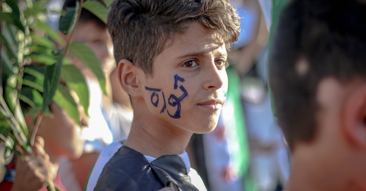 Any website that gather ongoing and upcoming strikes amongst airlines? - Side view of ethnic teenage boy with Arabic inscription on face standing on crowded street at protest movement against state policy