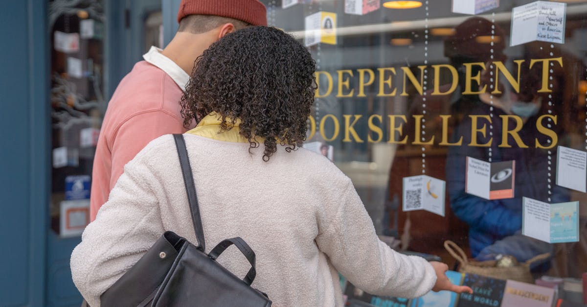 Anyone tried to bond merchandise in Qatar airport? - Anonymous couple hugging while standing on street near bookshop window