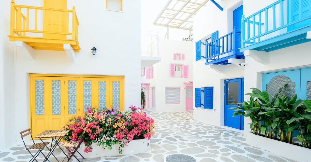 Apartment numbers in Greece [closed] - Architectural Photography of Three Pink, Blue, and Yellow Buildings
