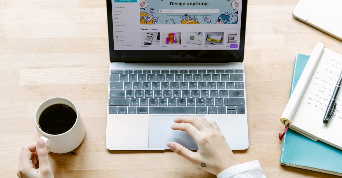 App or website showing cheap business class flights? - From above of crop anonymous person with cup of black coffee using laptop while sitting at table with opened notebook in daylight