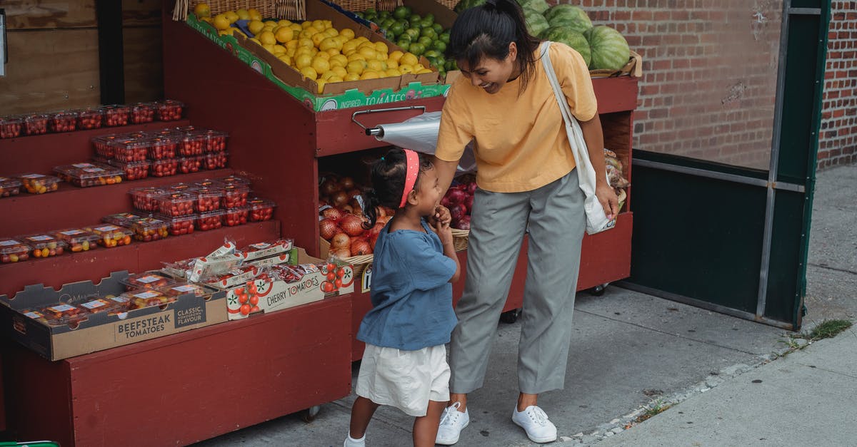 Apple Store in Ankara or Turkey - Cheerful ethnic woman with daughter at market with fruits