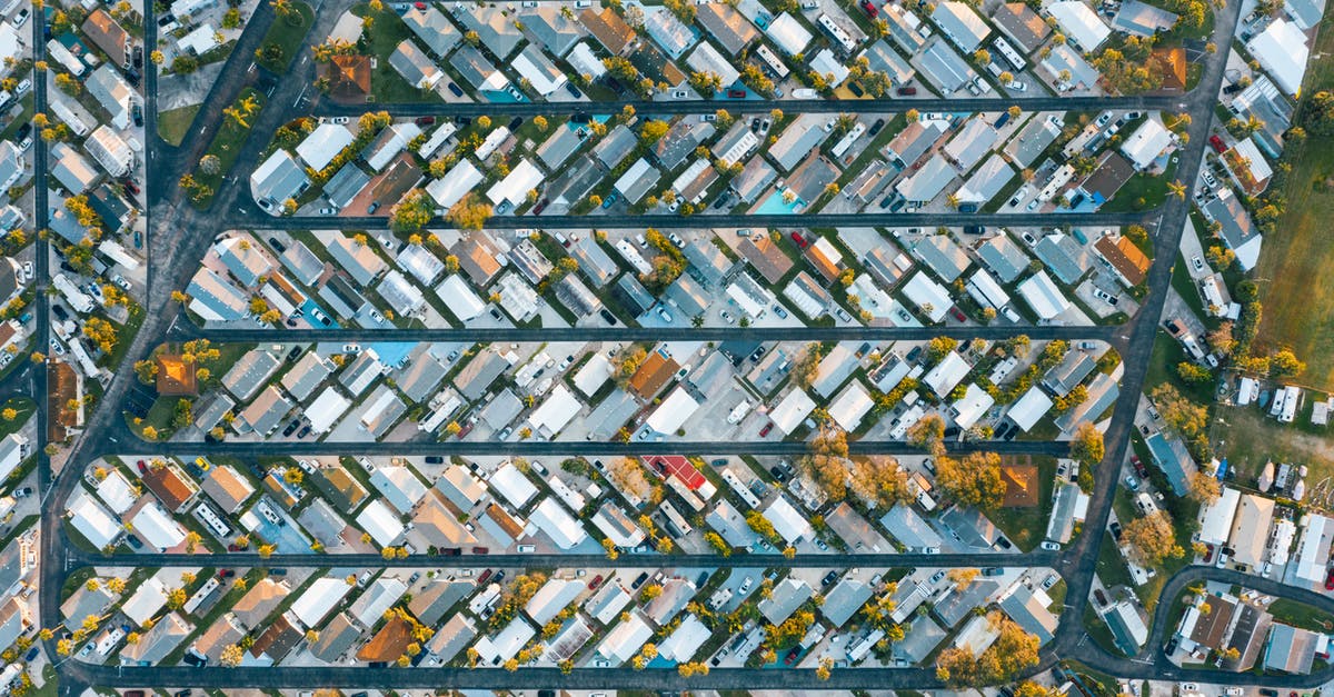 Application to plan optimal route between multiple cities - Drone view of modern buildings located in rows between roads in suburb of contemporary town on daytime