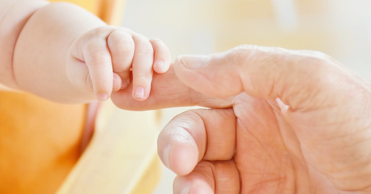 Applyin Child passport when dad is in India [closed] - Person Touching Hand of Baby