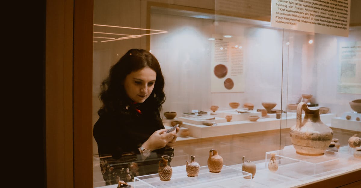 Applying again to visit UK, long term visit visa - Woman examining vases in exhibition hall