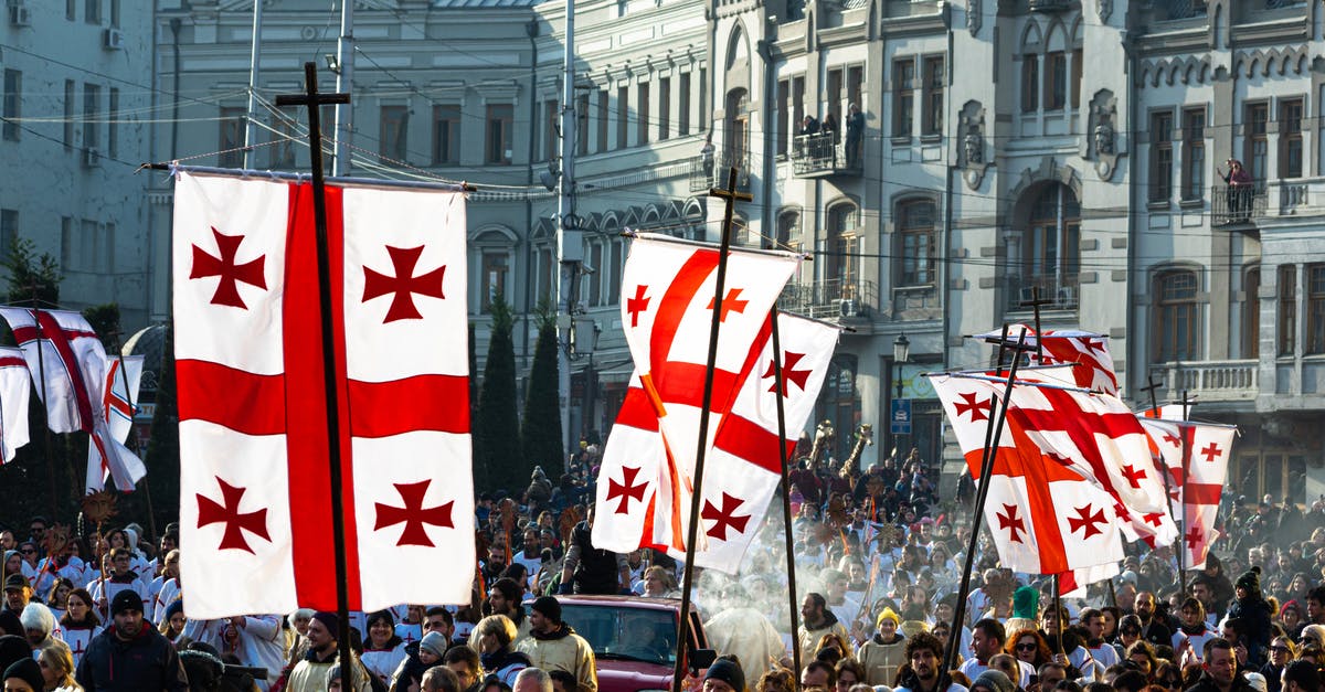 Applying for a Georgia tourism visa - Crowd of people waving flags of Georgia during celebration of religious holiday on Christmas day in Tbilisi