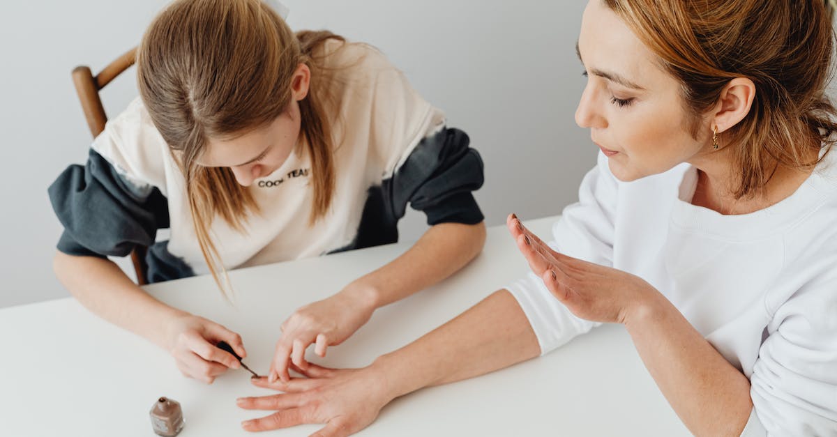 Applying for a Schengen Visa from within the UK - A Woman in White Sweater Blowing Her Hands with Nail Polish