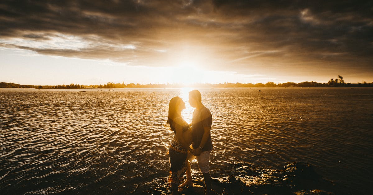 Applying for belgium visa with pregnant wife [closed] - Loving couple at seaside at sunset