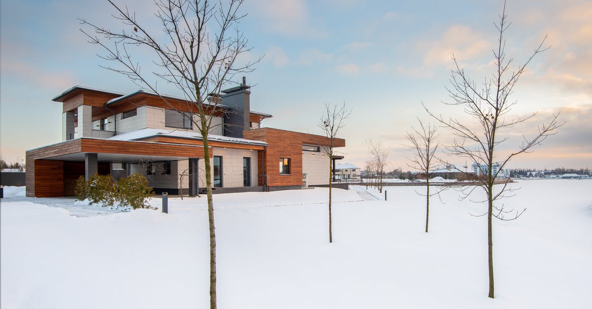 Applying for German visa from a country differnt than residence - Exterior design of new residential two storey house with modern stone and wooden facade and spacious yard located in suburban area in wintertime