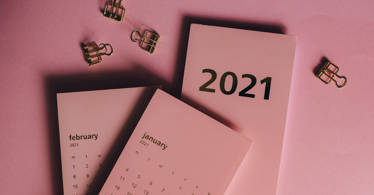 Appointment date - Top view of modern paper calendars with numbers and words near metal clips on pink background