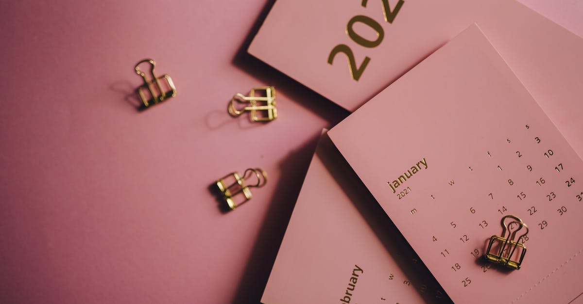 Appointment date - Overhead view of collection of modern monthly calendars near metal clips on pink table