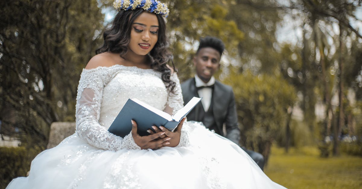 Apps to find local events - Happy multiethnic newlywed couple with Holy Bible in garden during wedding celebration