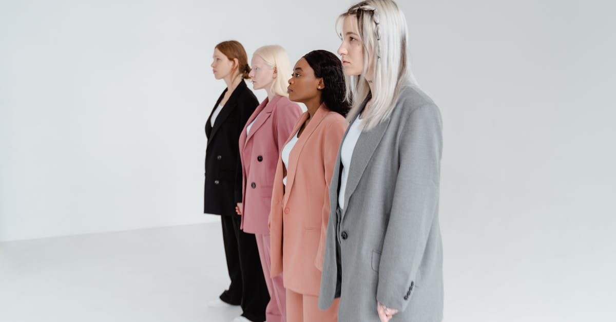 Are back-to-back working holidays in different countries possible? - Woman in Gray Blazer Standing Beside Woman in Pink Blazer