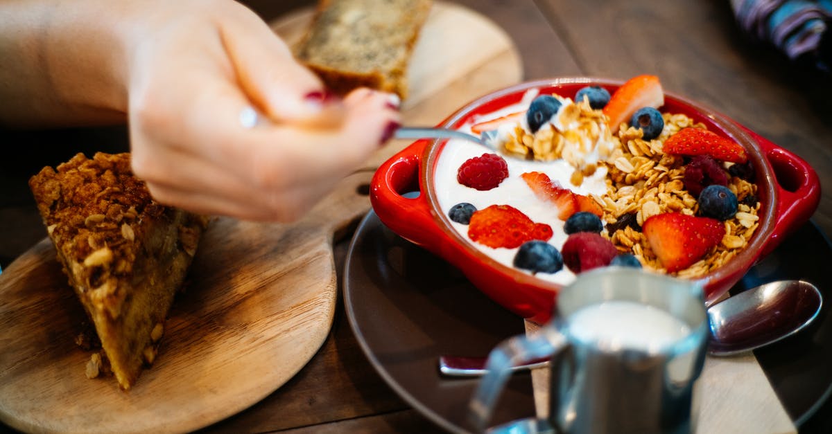 Are cream-filled pastries allowed in my carry-on? - Person Holding Spoon and Round Red Ceramic Bowl With Pastries