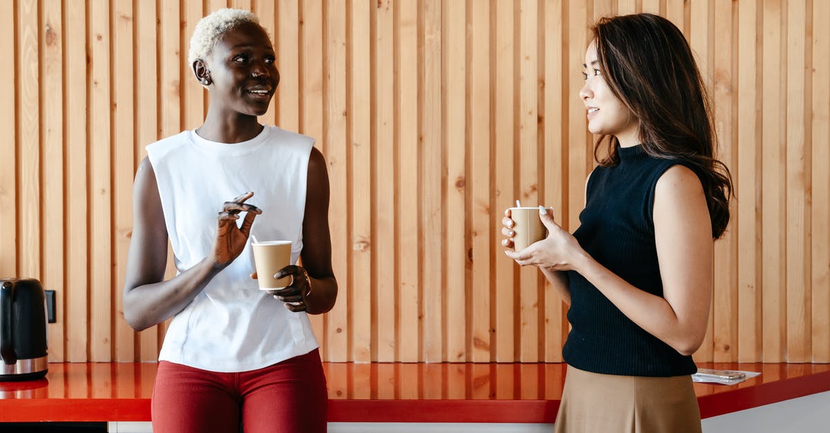 Are customs liable if they break something doing their job? - Happy multiracial women with cups of coffee smiling and discussing job in contemporary office