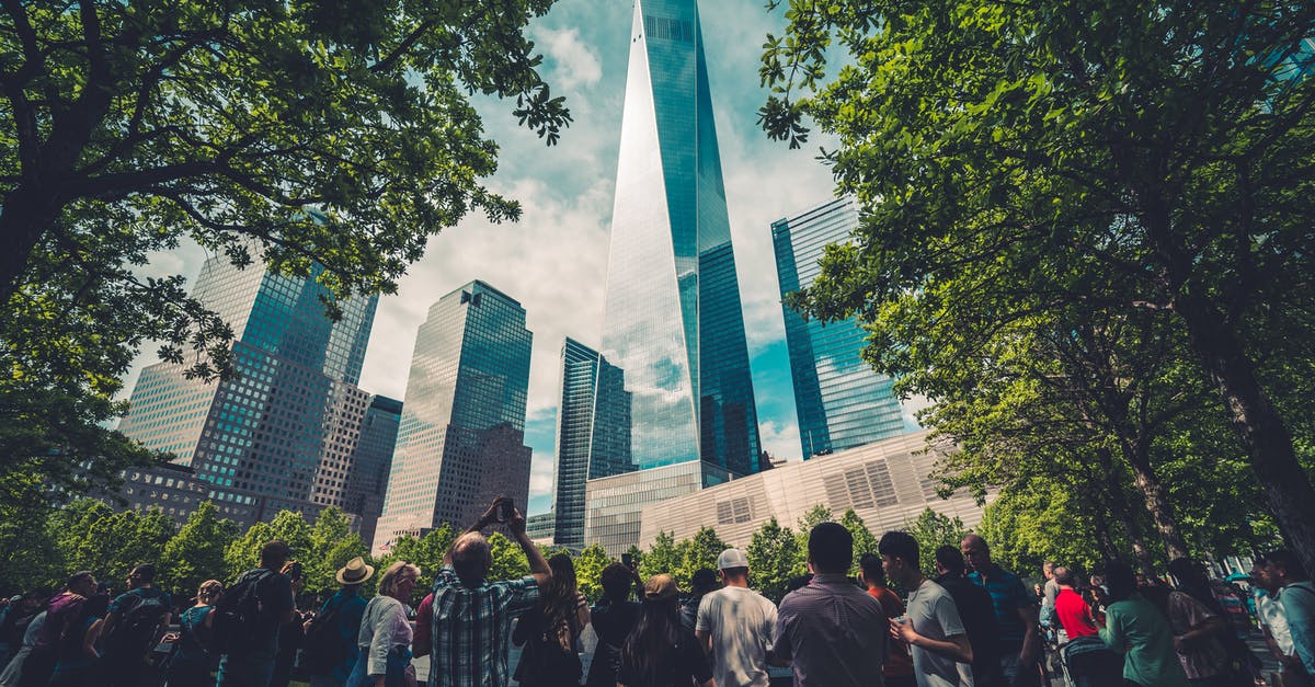 Are DSLR cameras permitted in NY & DC tourist attractions? - People Standing Across Glass Building