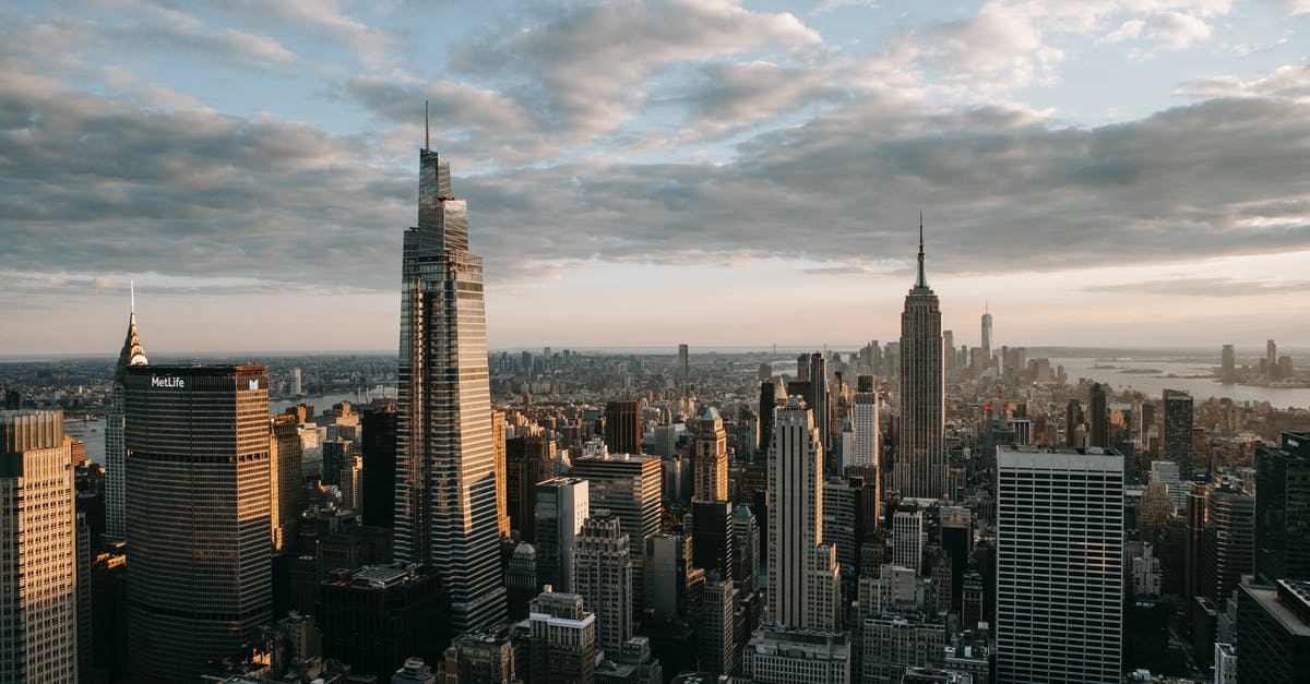 Are DSLR cameras permitted in the Empire State Building? - Multistage building facades with spires against ocean under cloudy sky in United States of America