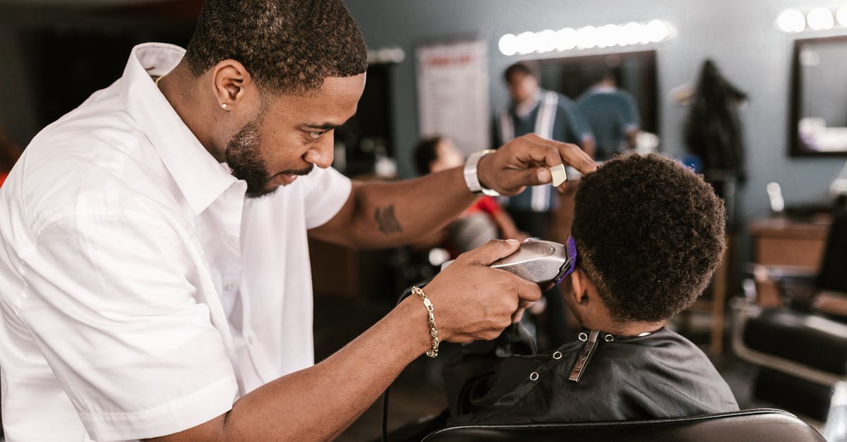 Are electric hair straighteners allowed on flights? - Man in White Dress Shirt Shaving Boy's Hair