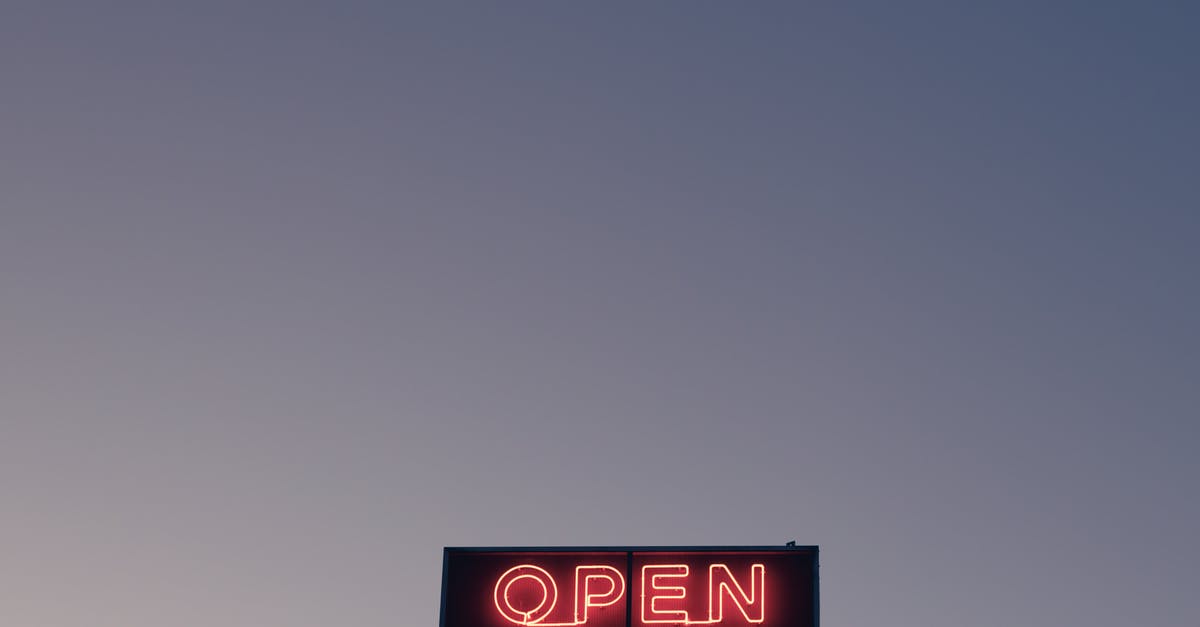 Are French beaches open for the public in general? - From below of illuminated signboard with Open red neon inscription against cloudless sunset sky