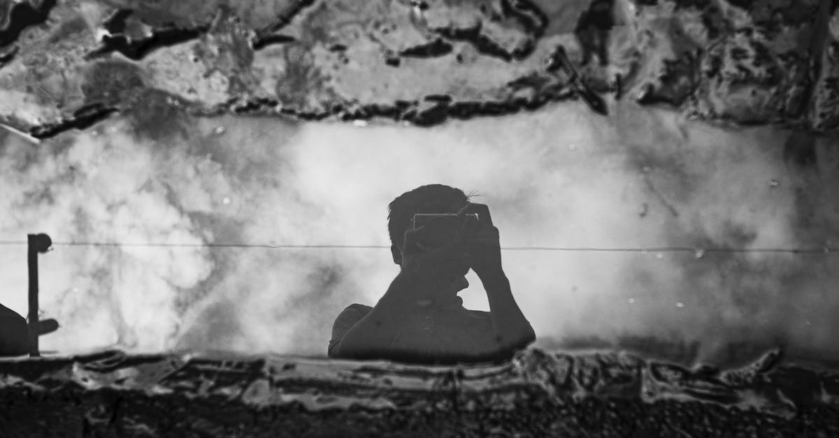 Are French hotels currently prohibited from using air conditioning? - Faceless photographer taking photo of puddle between dirt on camera