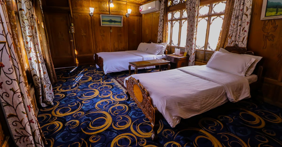 Are hotel beds rated? - Two Double Beds in the Room with Blue Carpet and Wooden Walls