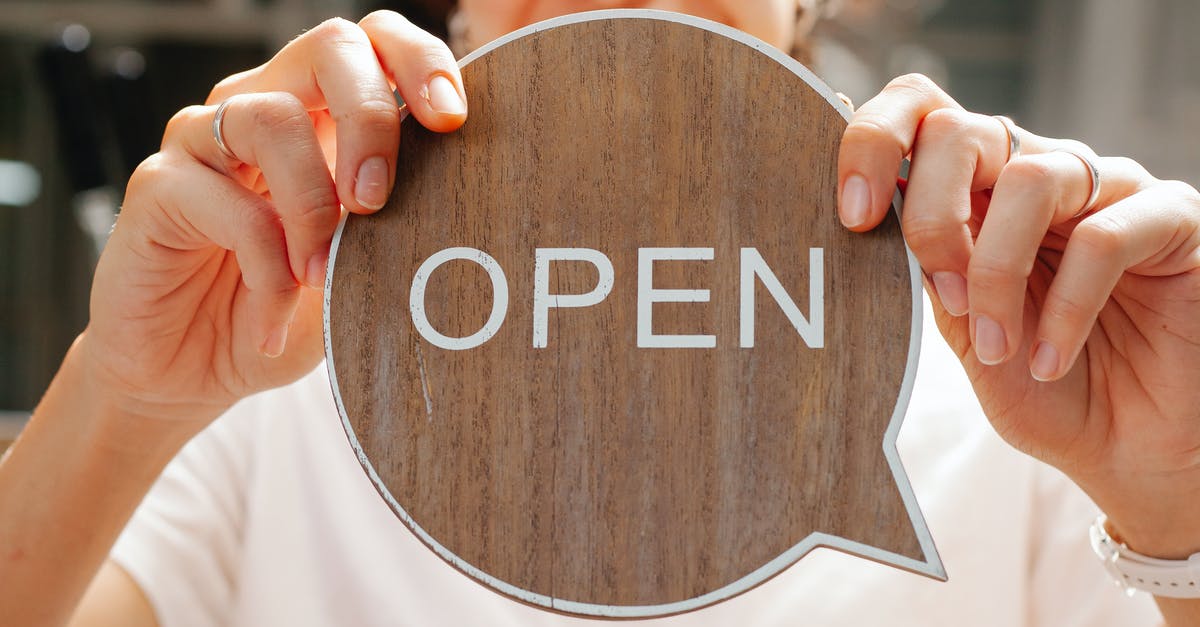 Are hotels open to public? - Happy woman showing wooden signboard saying open