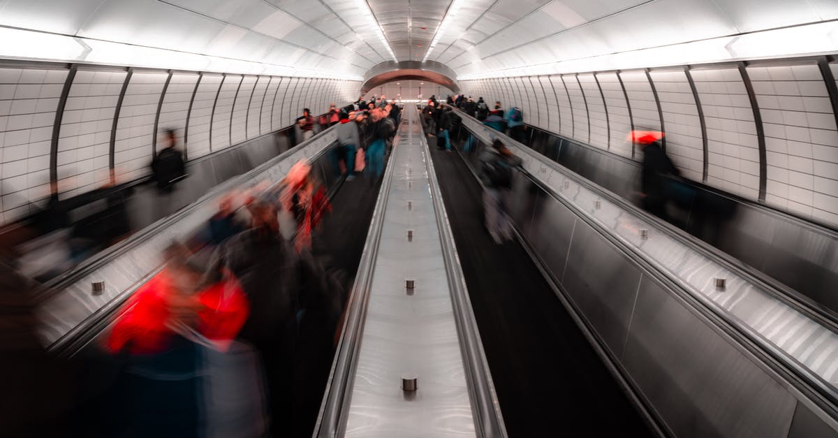 Are Italian residents exempt from needing a UK direct airside transit visa? - Anonymous people on escalator in modern subway