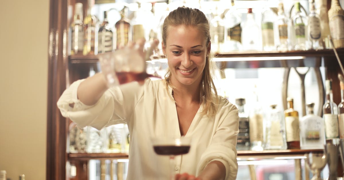 Are izakaya where the bartender doesn't stand opposite the bar inauthentic? - Cheerful female bartender pouring cocktail in bar