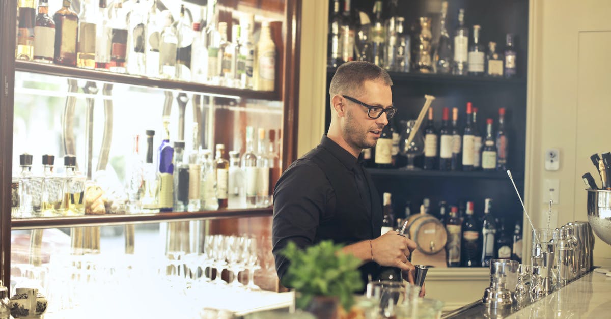 Are izakaya where the bartender doesn't stand opposite the bar inauthentic? - Man in Black Top Standing in Front of Bar Counter