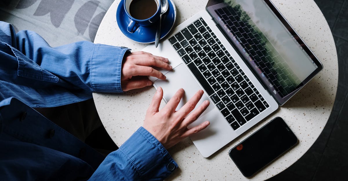 Are keypad phones allowed in flights? [closed] - Person in Blue Denim Jeans Using Macbook Pro Beside White Ceramic Mug on White Table