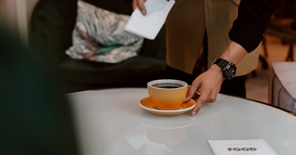 Are MasterCard and Visa accepted by Amsterdam taxis? - Person Holding White Ceramic Cup With Brown Liquid