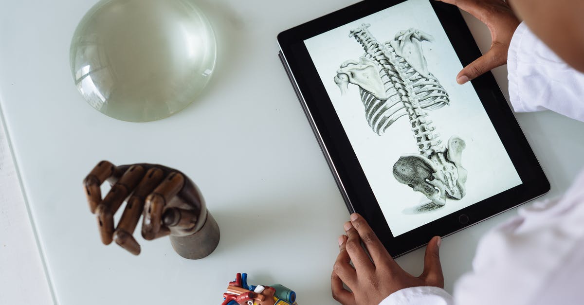 Are medical doctors legally doctors wherever they are? - Unrecognizable African American scientist studying anatomy with tablet