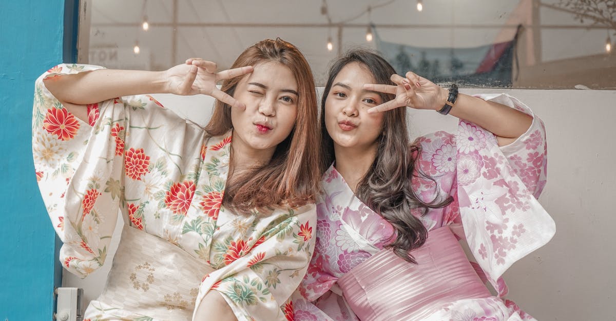 Are most flights to Japan staffed by hosts with good Japanese? - Woman in White and Red Floral Dress Lying on Bed