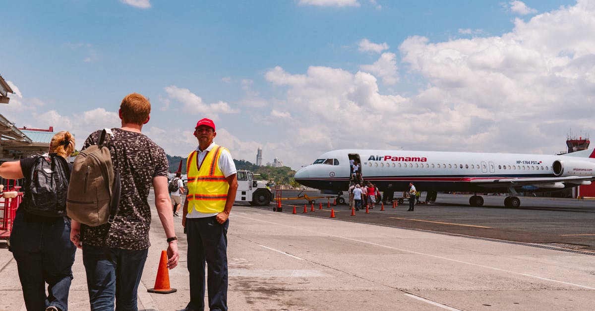 Are most staff at Brussels airport Dutch or French-speaking? - Standing Person Wearing Yellow and Red Vest