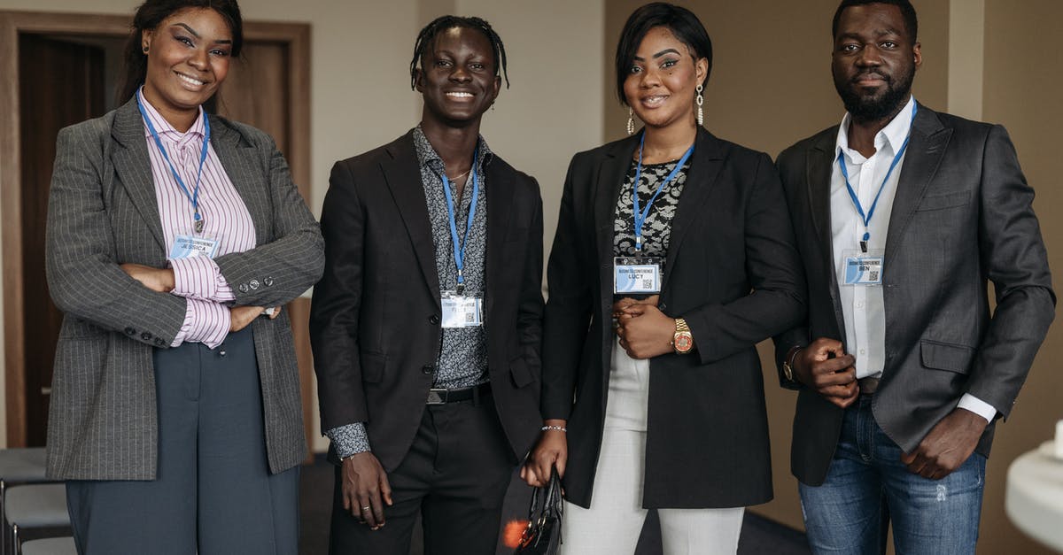 Are "TAXI" badge wearing people at the exit of FCO legal? - Group of People Wearing Corporate Attire and Badge Smiling